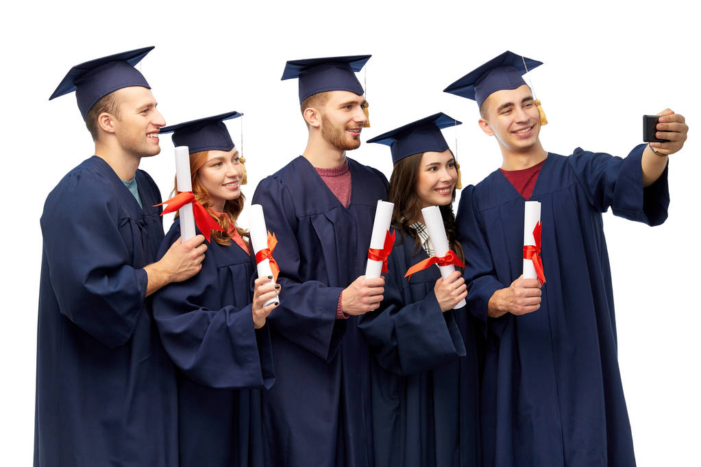 graduados con diplomas tomando selfie por teléfono celular
 - Foto, Imagen