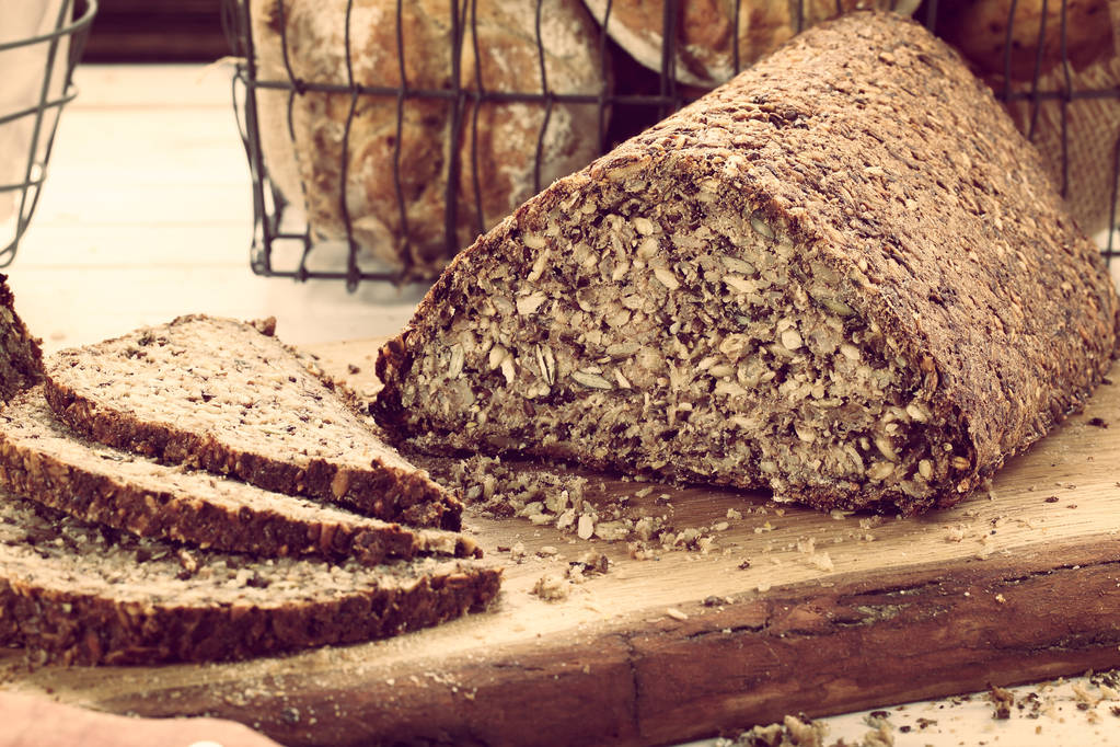 Свіжий шматочок хліба і різання на сільській дерев'яній тарілці
 - Фото, зображення