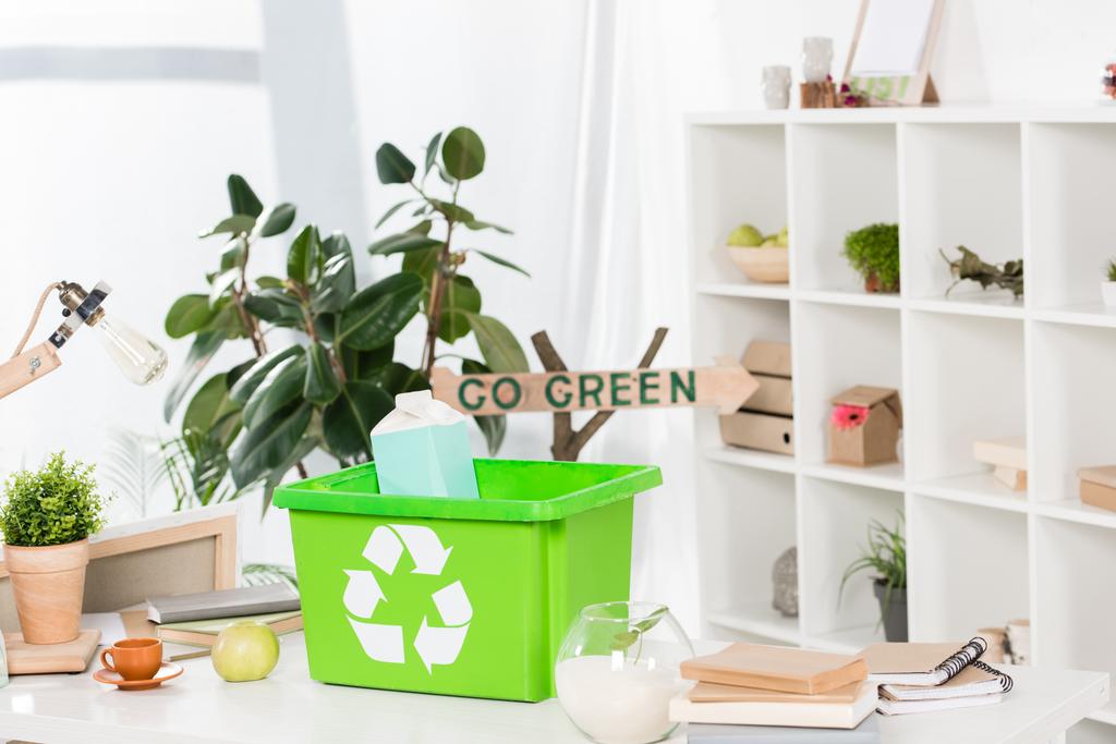 foyer sélectif de la boîte de recyclage verte avec paquet de lait de papier sur le bureau avec go signe vert sur le fond, concept d'économie de l'environnement
  - Photo, image