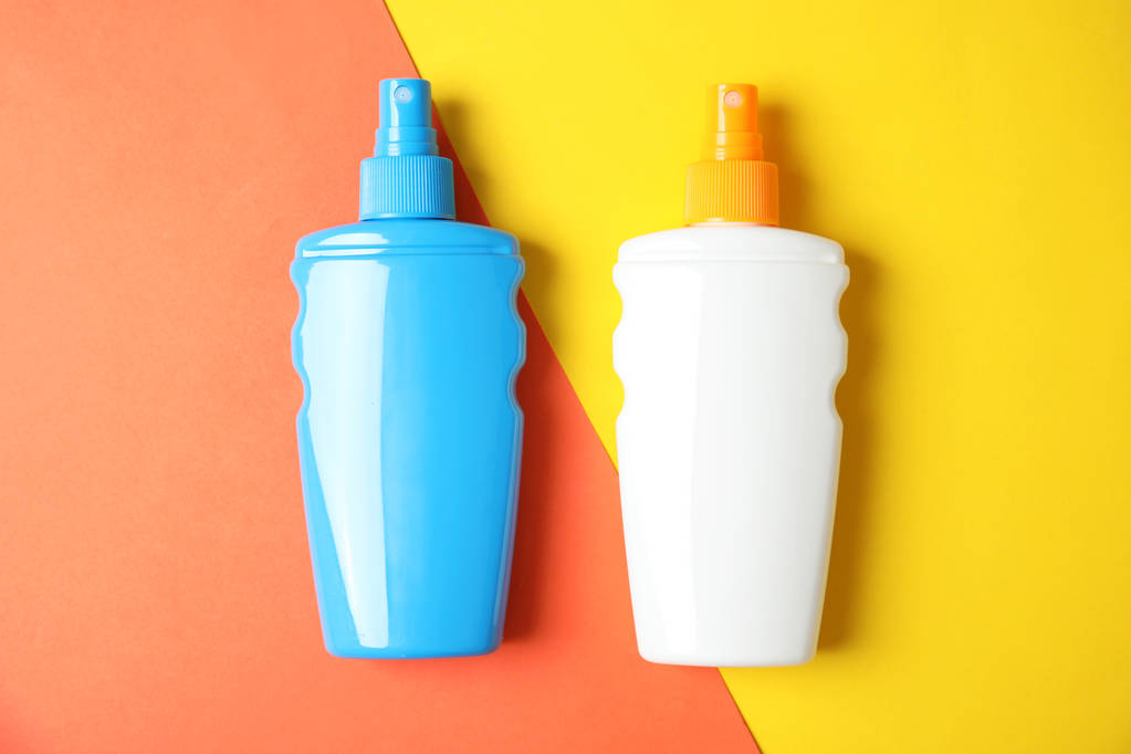 Botellas con crema corporal de protección solar sobre fondo de color, vista superior
 - Foto, imagen