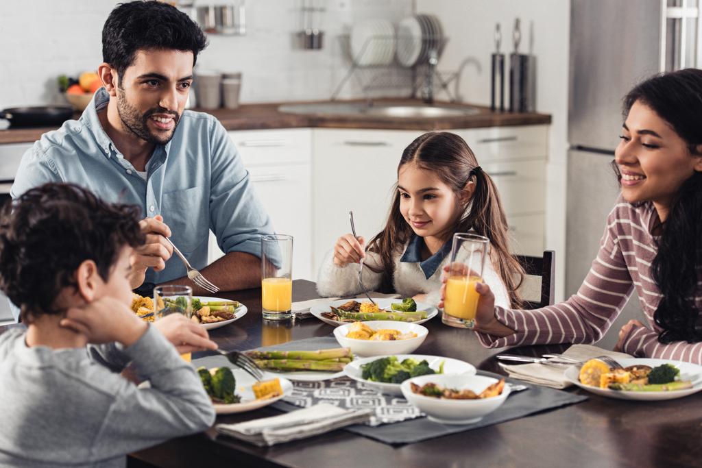 felice famiglia ispanica sorridente mentre pranza a casa
 - Foto, immagini