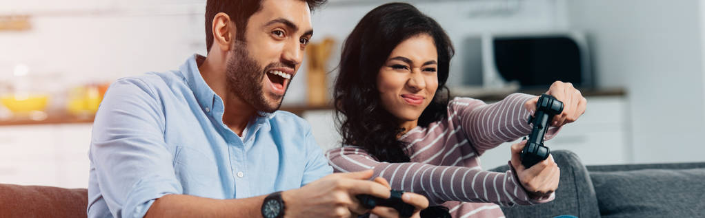 happy latin man playing video game with wife at home - Photo, Image