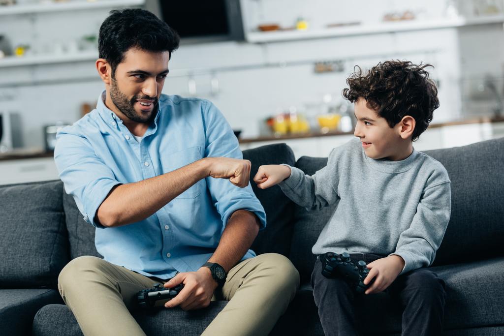 evde video oyun oynadıktan sonra oğluna yumruk çarpmak vererek neşeli latin baba  - Fotoğraf, Görsel