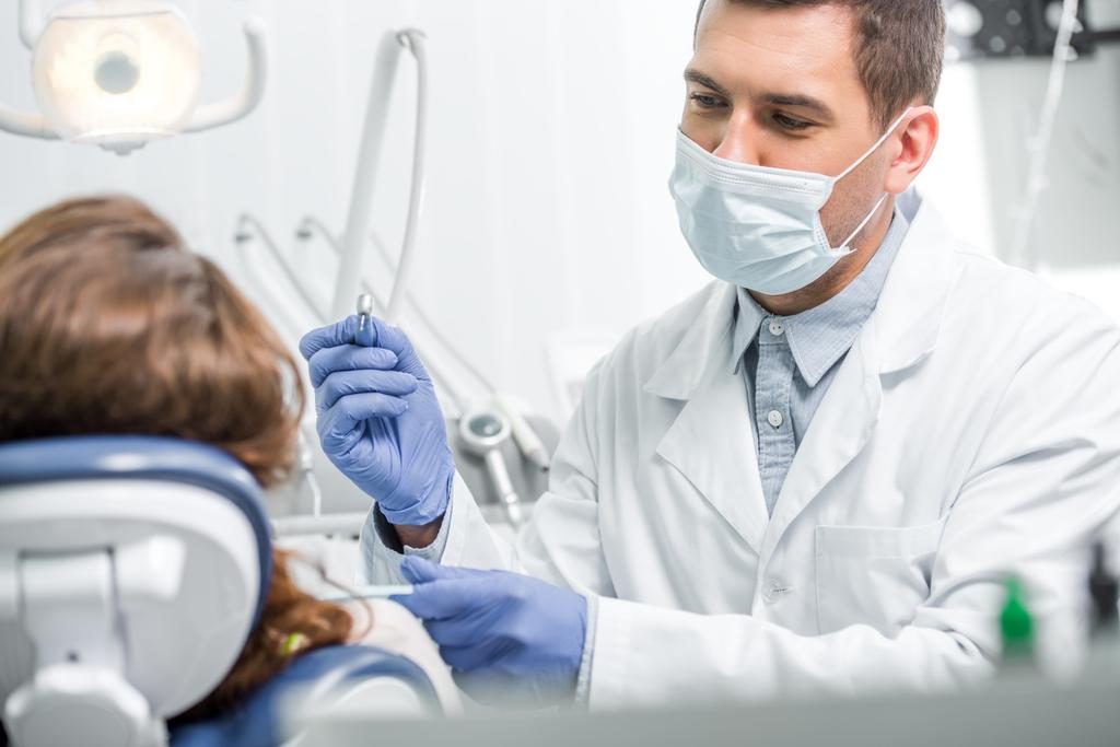 Selektywny fokus z dentysta w maska badanie pacjentki - Zdjęcie, obraz