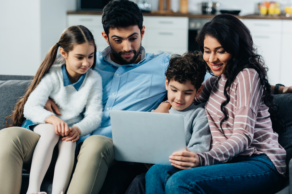 gelukkige Spaanse familie laptop thuis kijken - Foto, afbeelding