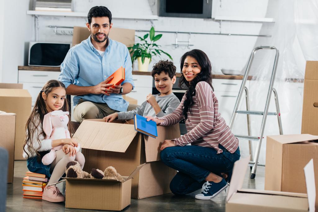 alegre familia hispana desempacando cajas en nuevo hogar
  - Foto, Imagen