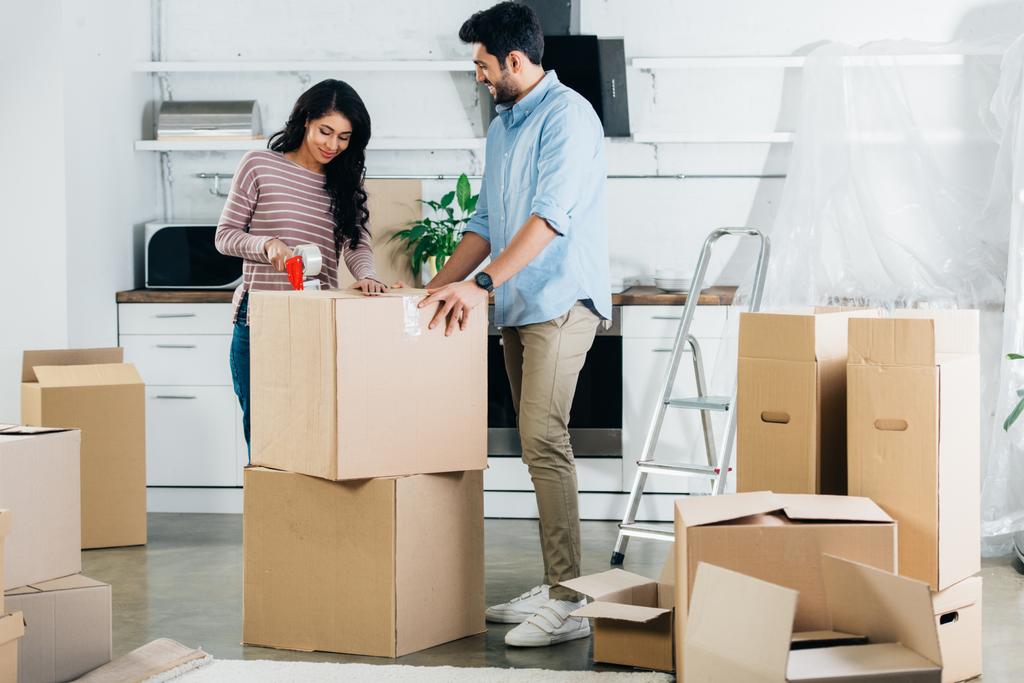 alegre casal latino caixas de embalagem ao se mudar para a nova casa
 - Foto, Imagem