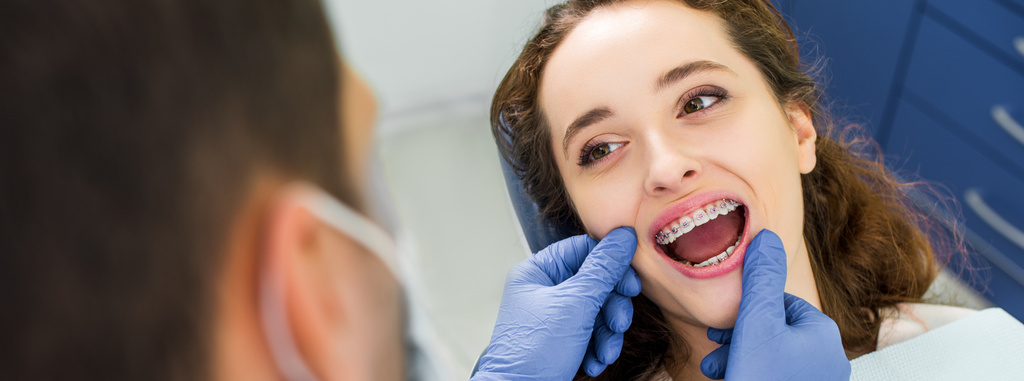 付近の歯科医で歯の検査中に口を開く中かっこで陽気な女性の選択と集中 - 写真・画像