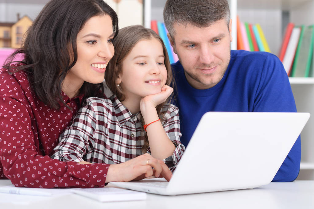 szülők és lánya használja laptop a szobában - Fotó, kép