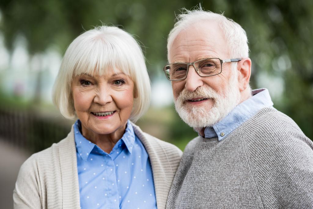boldog idősebb pár mosolygó és látszó-on fényképezőgép  - Fotó, kép