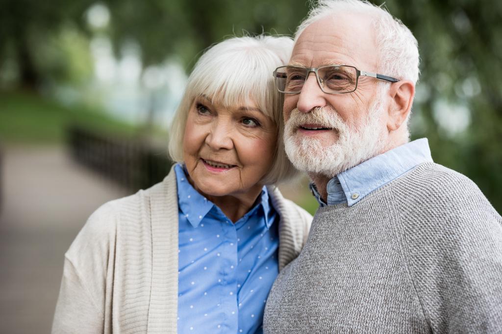 Щаслива старша пара посміхається і дивиться геть
  - Фото, зображення