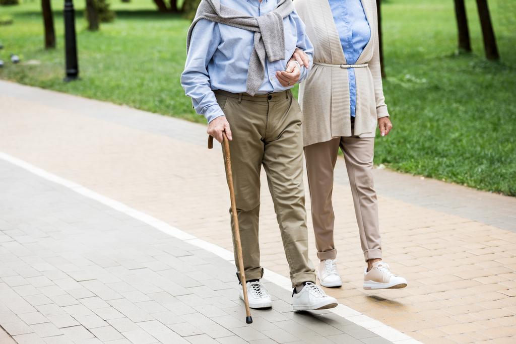 cropped view of senior couple walking in park - Photo, Image