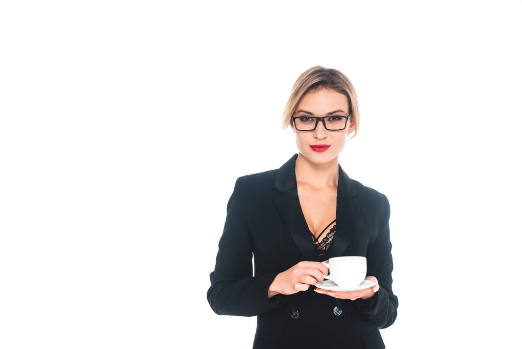 бізнес-леді в чорному формальному одязі з відкритим вирізом, що п'є з чашки ізольовано на білому
 - Фото, зображення