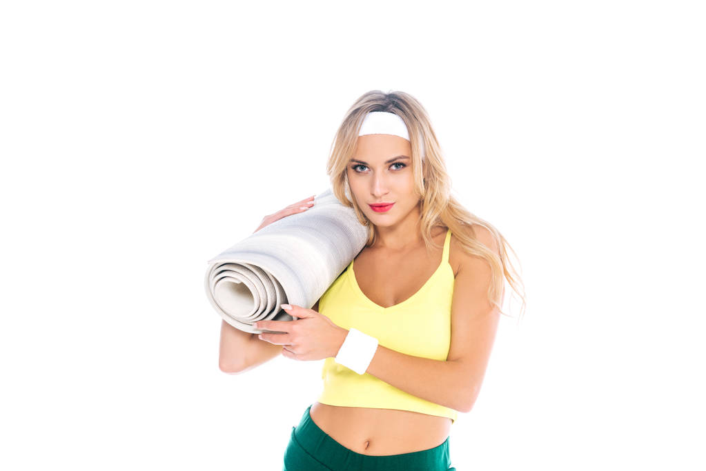 entraîneur de fitness blonde en short vert et singulet jaune tenant tapis de yoga isolé sur blanc
 - Photo, image