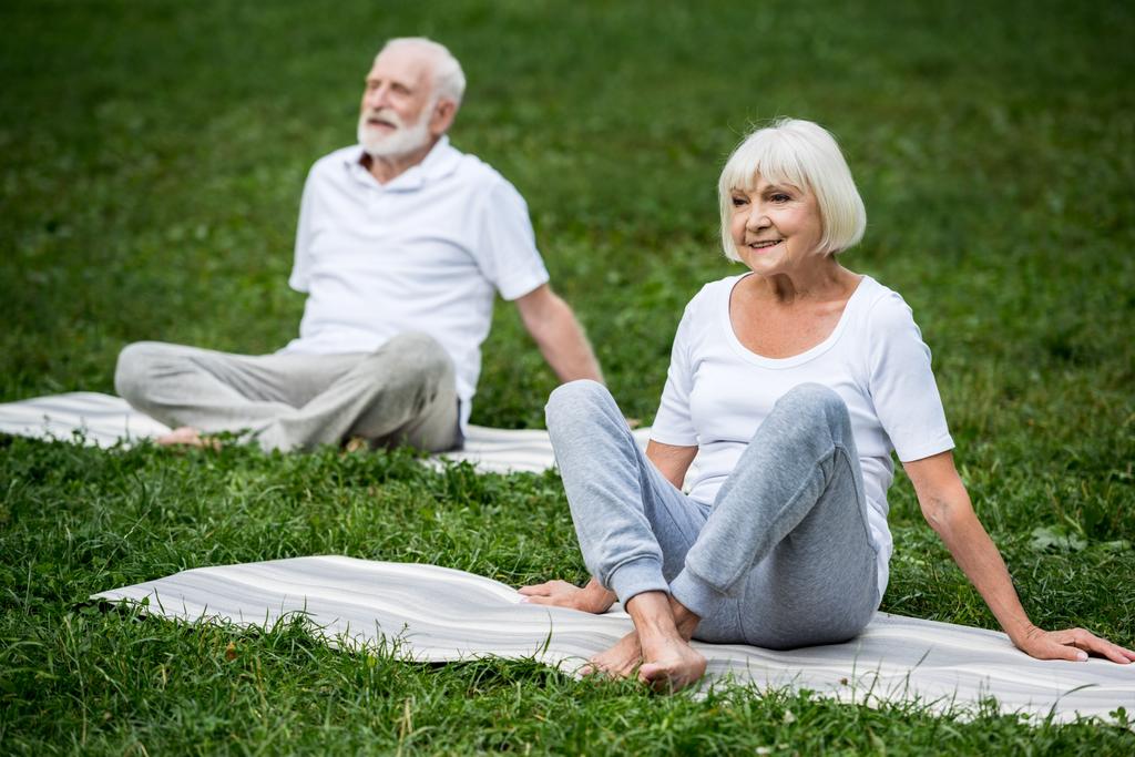couple de personnes âgées méditant dans des poses de relaxation tout en étant assis sur des tapis de yoga
  - Photo, image