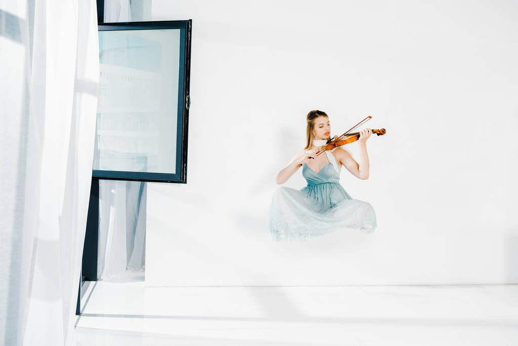 плаваюча дівчина в блакитному десерті грає на скрипці на білому тлі
  - Фото, зображення