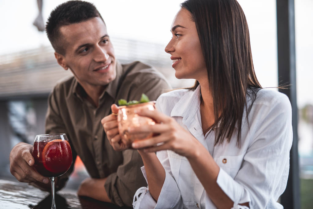 Primo piano di giovani coppie che bevono cocktail al bancone del bar
 - Foto, immagini
