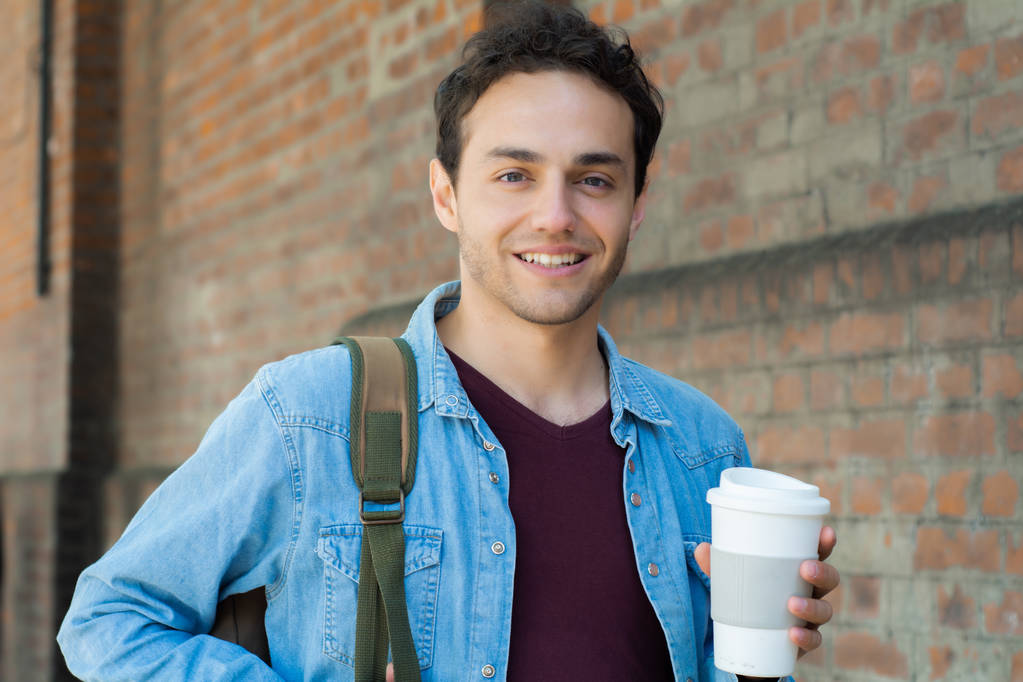 Young handsome man with disposable coffee. Take away concept. Outdoors  - Photo, Image