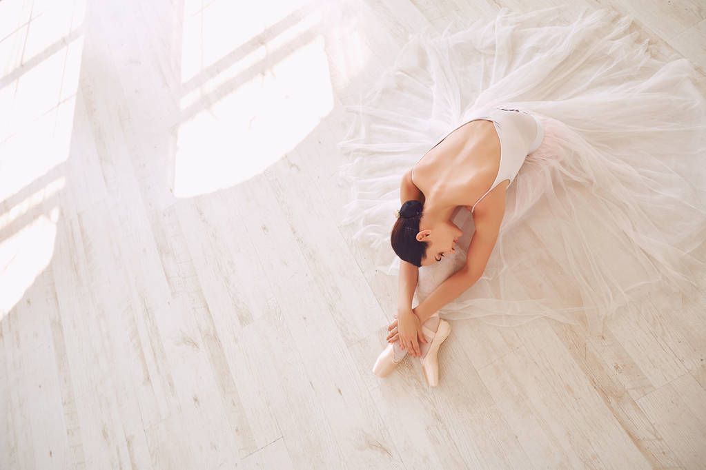 Mladá baletka pózuje na podlaze - Fotografie, Obrázek
