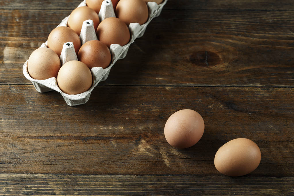 chicken eggs in a paper tray on wooden background. space for tex - Photo, Image