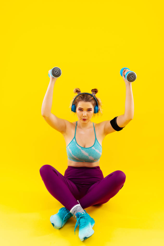 Vrouw verliezen van gewicht zittend op de vloer en het doen van oefeningen - Foto, afbeelding