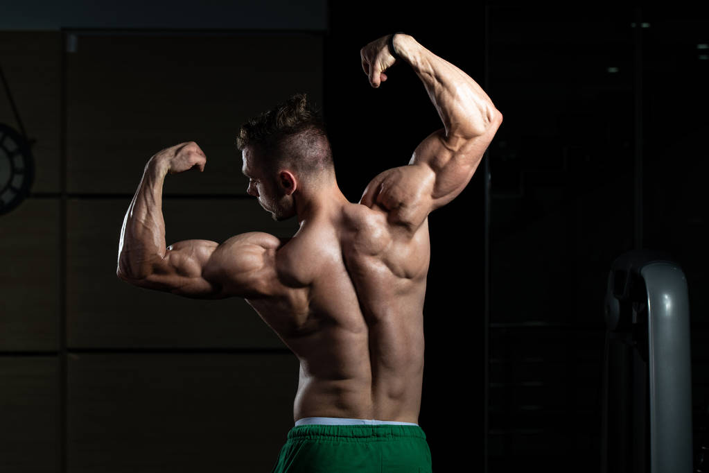 ジムや屈曲筋肉に強い立って若い男-運動後の筋肉運動体ビルダーフィットネスモデルのポーズ - 写真・画像
