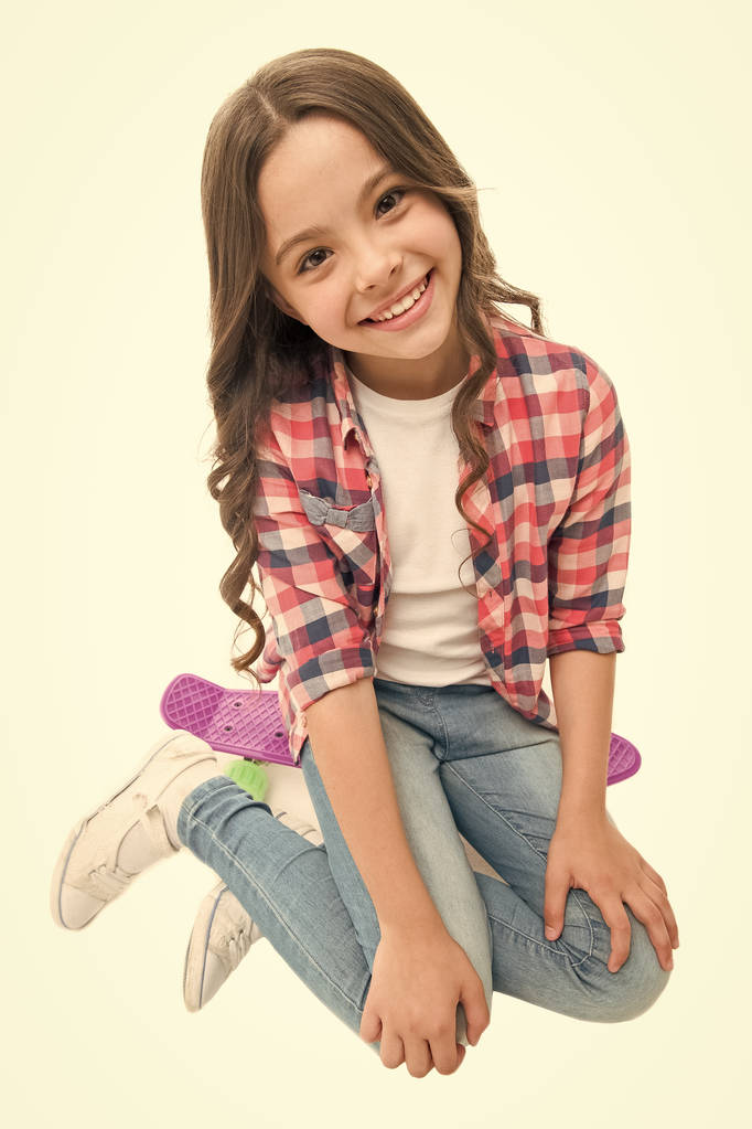 Happy ride. Kid girl happy sits penny board. Originally designed as girls skateboard. Modern teen hobby. Girl happy face sit on penny board white background. Learning how to ride penny board - Photo, Image