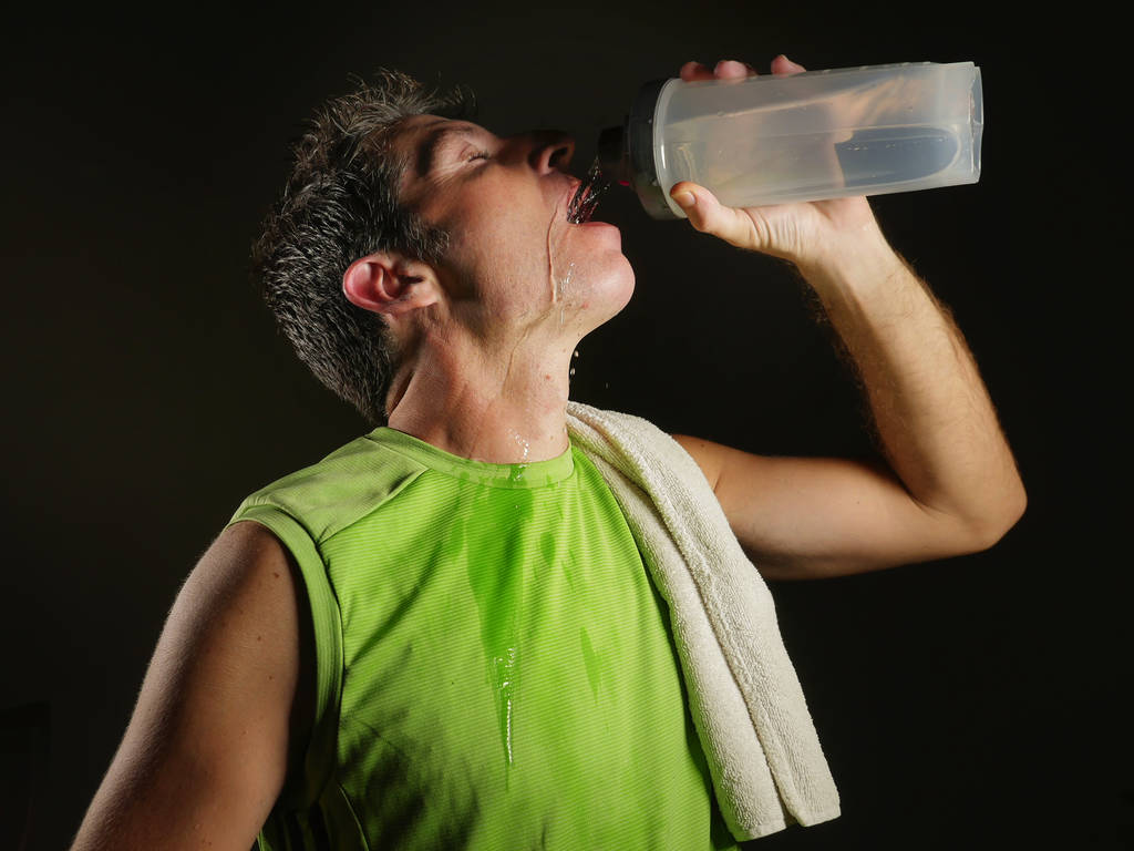 若い汗魅力的でフィット スポーツ男ハード フィットネス トレーニング体操クラブでは健康的なライフ スタイルやトレーニングの黒い背景に分離後、クーリングオフのボトルを保持している水を飲む - 写真・画像
