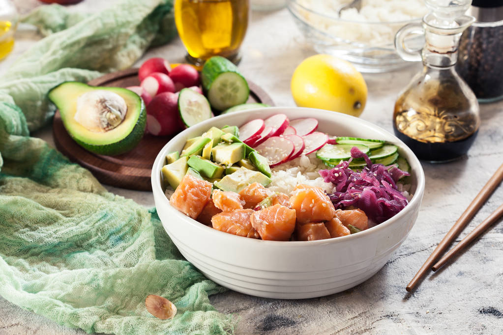 Pirinç, avokado, salatalık ve turp parlak zemin üzerine kase, geleneksel Hawaii çiğ balık salata poke - Fotoğraf, Görsel
