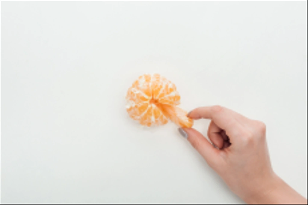 cropped view of woman holding tangerine slice on white background - Photo, Image