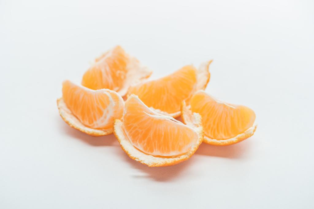rijpe tangerine segmenten met peel op witte achtergrond - Foto, afbeelding