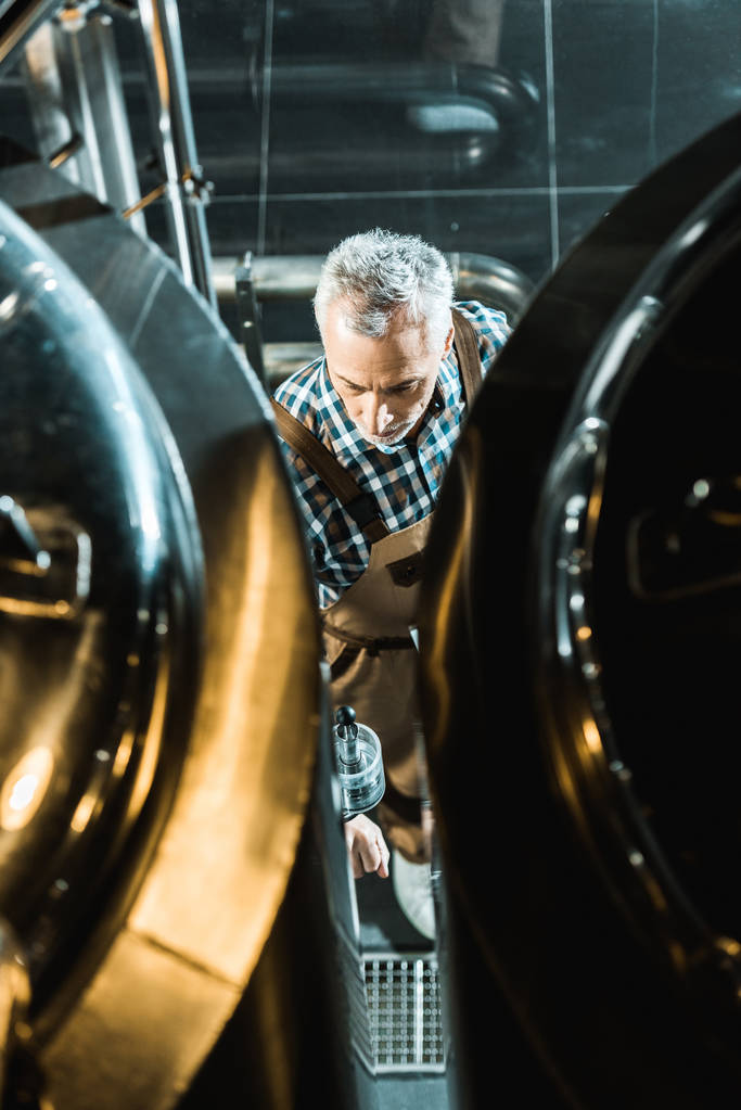 プロの男性ビール醸造設備での作業のオーバー オールでのオーバー ヘッド ビュー - 写真・画像