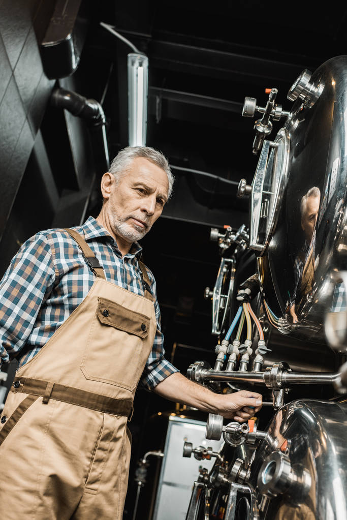 Profi-Brauer arbeitet mit Brauereiausrüstung - Foto, Bild