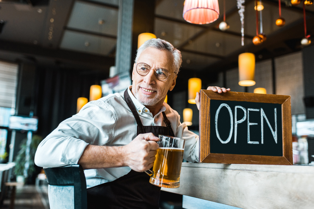 vezető sörfőző gazdaság nyitott jele és a pohár sör pub  - Fotó, kép