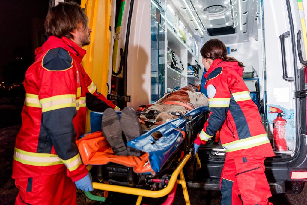 Paramedics transportating patient on gurney in ambulance car - Photo, Image