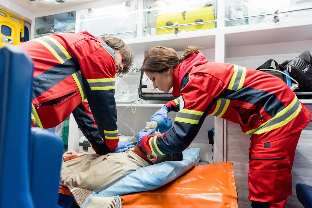 Paramédicos haciendo resucitación cardiopulmonar en coche ambulancia
 - Foto, imagen