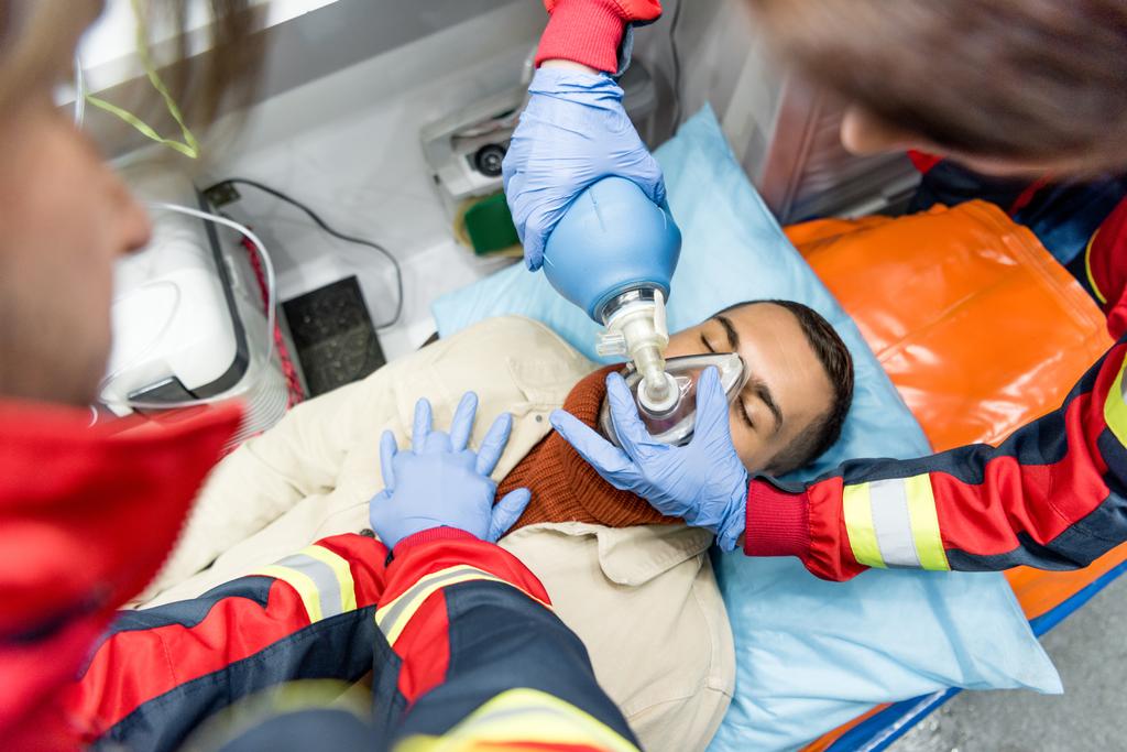 Ensihoitajat tekevät kardiopulmonaalista elvytystä ambulanssiautossa
 - Valokuva, kuva