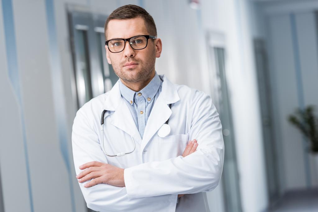 Jeune médecin en lunettes debout avec les bras croisés
 - Photo, image
