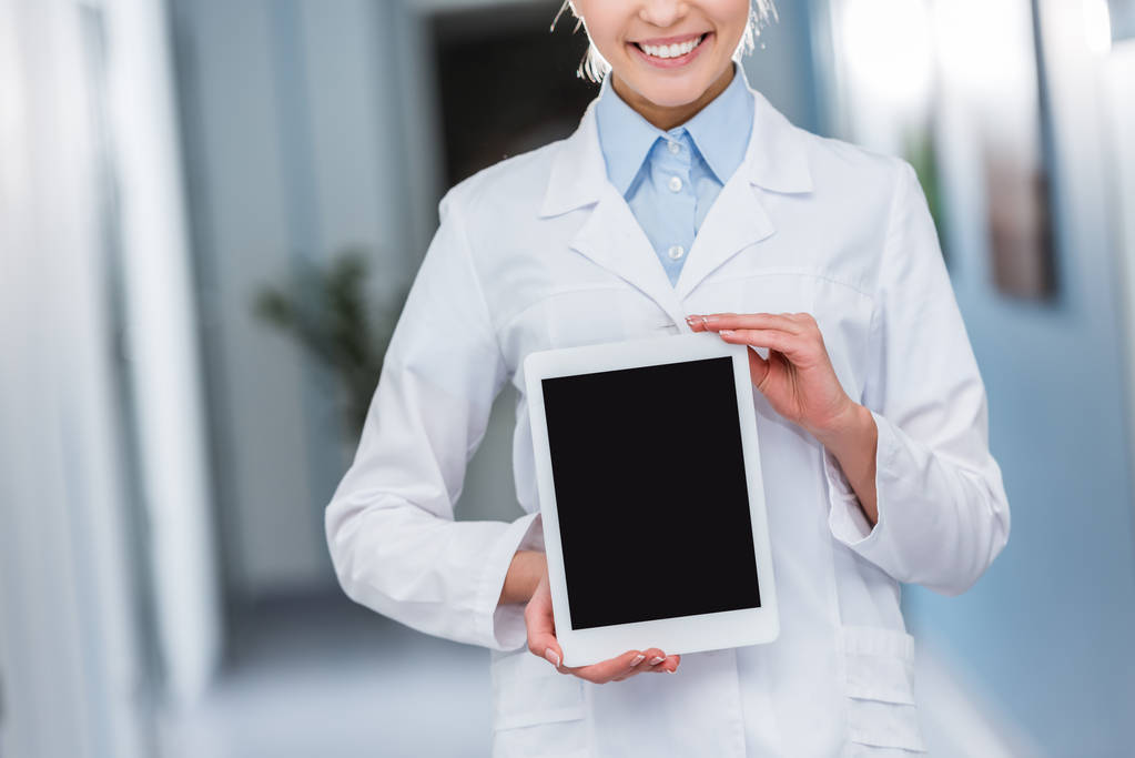 Vista recortada del médico sonriente sosteniendo la tableta digital con pantalla en blanco
 - Foto, imagen