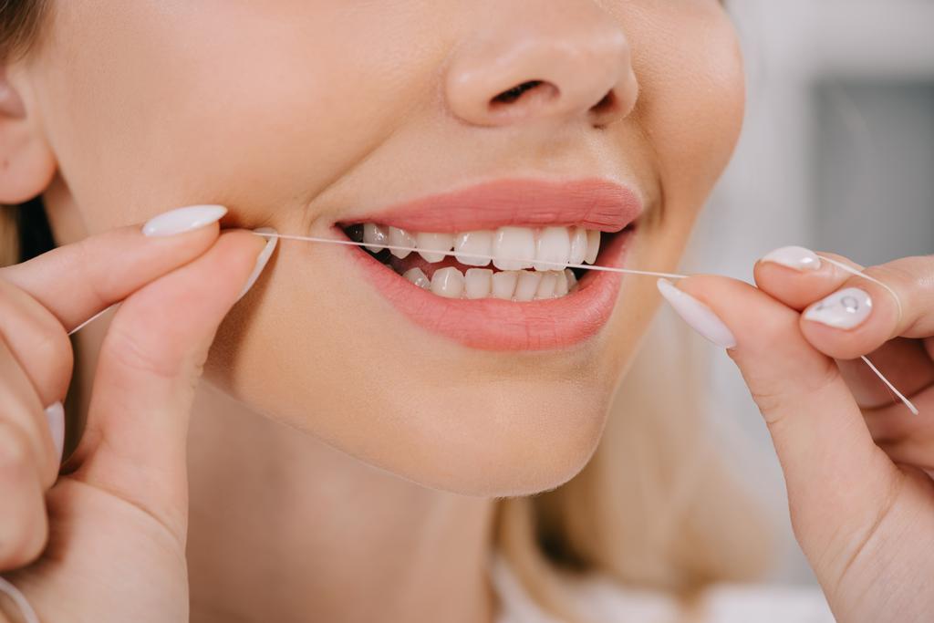 vista parziale dei denti donna filo interdentale con filo interdentale
 - Foto, immagini