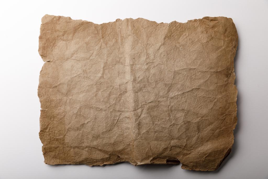 верхний вид старого листа бумаги, лежащего на белом фоне
  - Фото, изображение