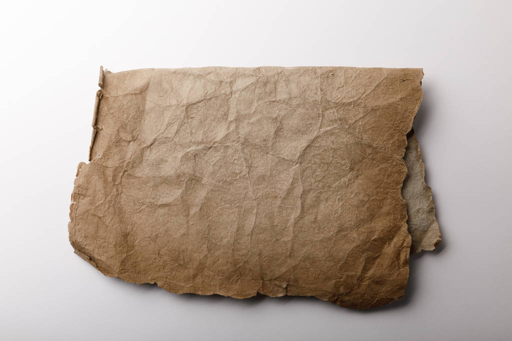 vista superior del papel pergamino viejo acostado sobre fondo blanco
  - Foto, Imagen