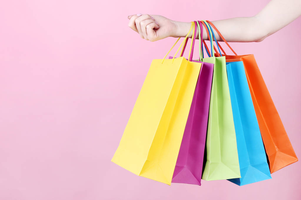 Pembe renkli alışveriş torbaları tutmak el - Fotoğraf, Görsel