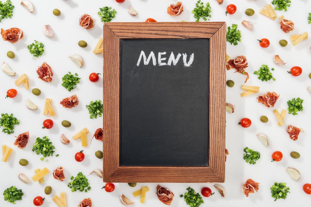 lavagna di gesso con scritte di menu tra olive, spicchi d'aglio, prosciutto, verde, formaggio tagliato e pomodorini
 - Foto, immagini