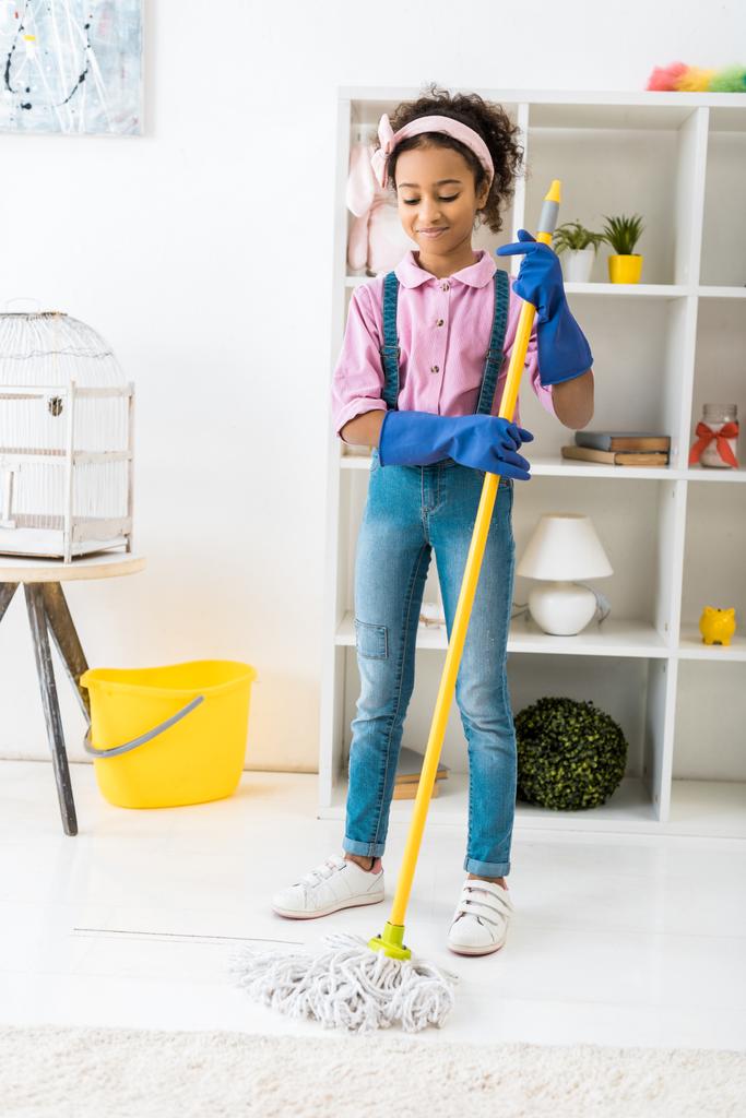 adorable afroamericano chica limpieza piso con fregona
 - Foto, Imagen