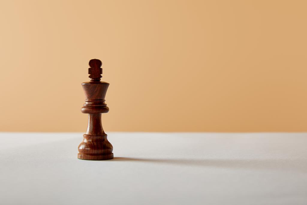 wooden king piece on white table and beige background - Photo, Image