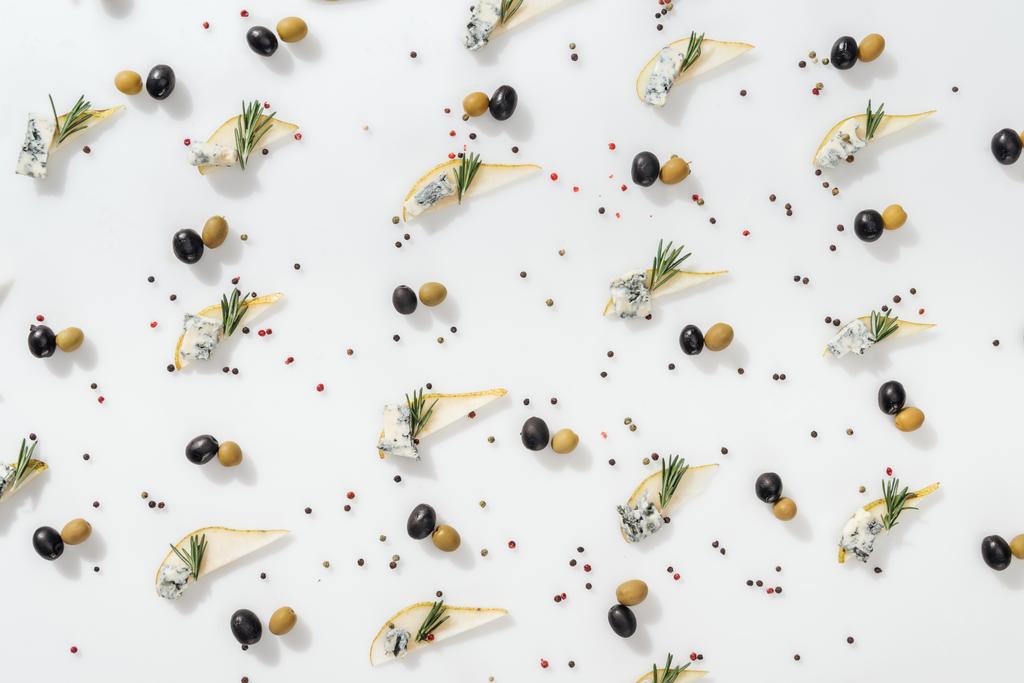 tendido plano de peras en rodajas con queso azul y ramitas de romero cerca de aceitunas negras y verdes sobre fondo blanco
 - Foto, imagen