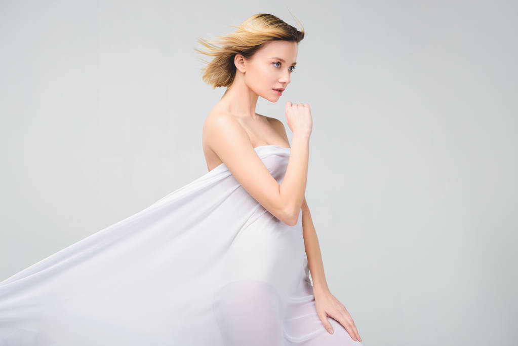элегантная обнаженная девушка позирует в белой ткани, изолированная на серой
 - Фото, изображение