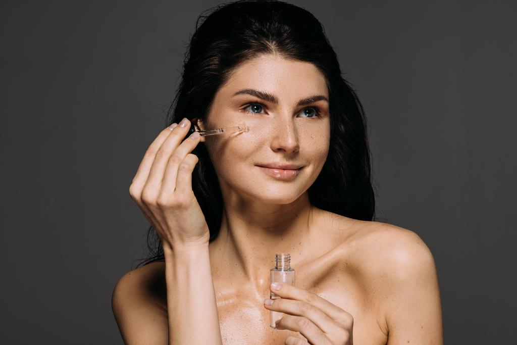attraktive nackte Frau Anwendung Serum mit Pipette isoliert auf grau - Foto, Bild