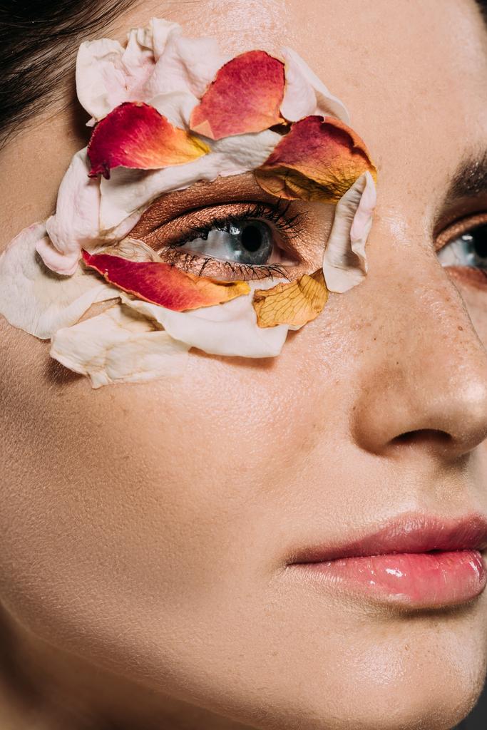 κοντινό πλάνο του ελκυστική κοπέλα με floral πέταλα γύρω από τα μάτια  - Φωτογραφία, εικόνα